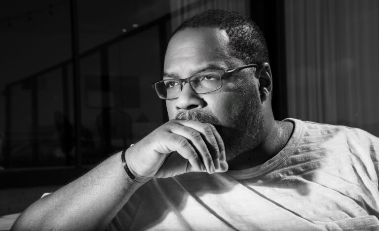 Black and white portrait of Quincy James Freeman, hand on chin, looking out a window